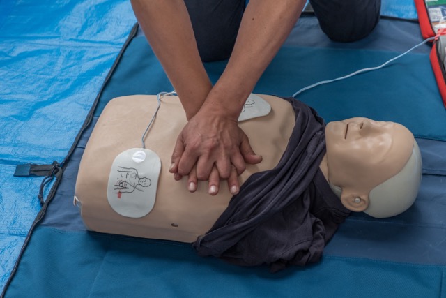 hands on first aid training session as part of course, cpr being demonstrated by first aid course leader