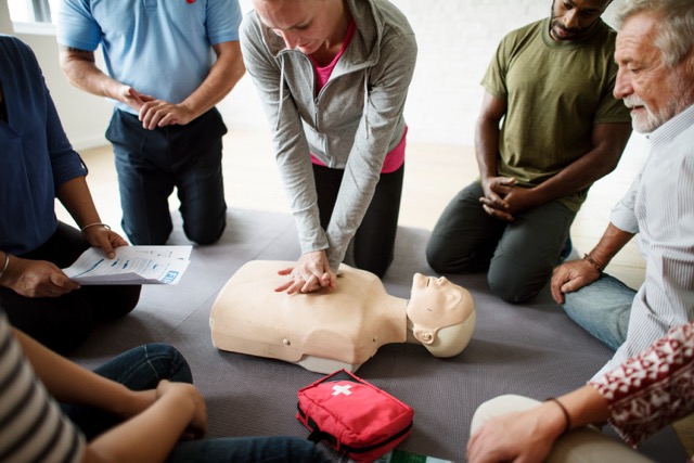 student learning and showing how cpr is performed on a first aid training course in the uk run for employees and students
